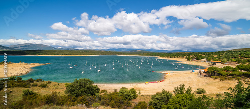 Fototapeta Naklejka Na Ścianę i Meble -  Atazar Reservoir with pleasure boats to navigate. Panoramic with blue sky and white clouds. Madrid.
