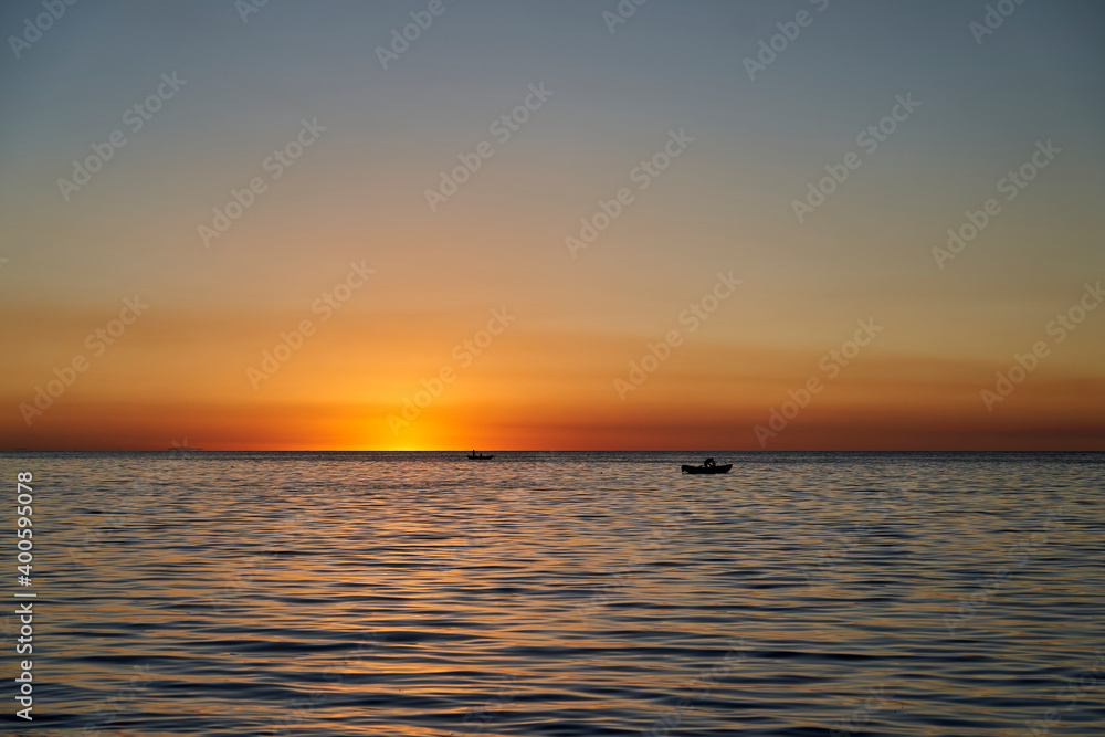 Beautiful golden sunset over lake titicaca with the silhouette of a fisherman in his boat, close to copa cabana in Bolivia, South America