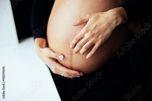 Close up photo shoot of pregnant bump with hands on it.