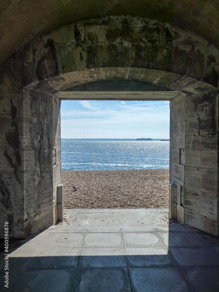 coastal scene framed by a brick archway