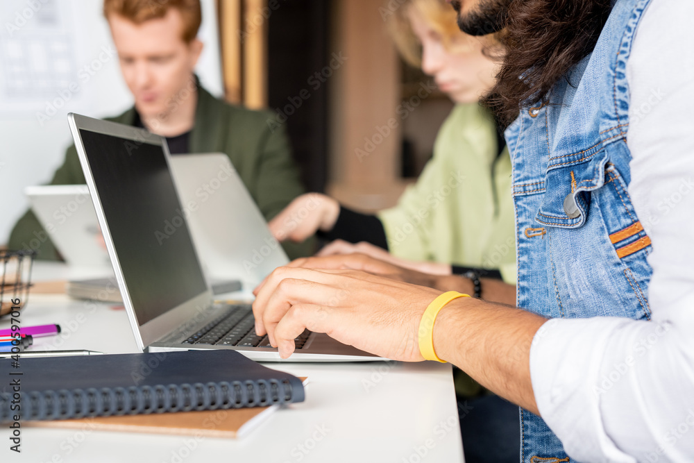 Side view of hands of young mixed-race businessman in casualwear networking Side view of hands of young mixed-race businessman in casualwear networking