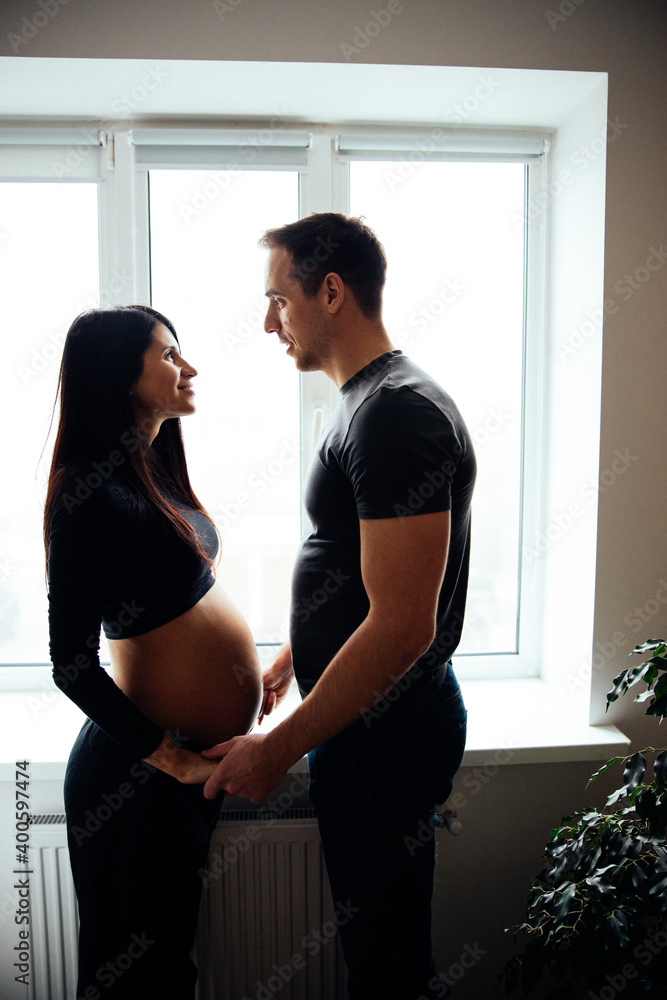Affectionate pregnancy photo shoot at home. Spouses are waiting for the baby. Affectionate pregnancy photo shoot at home. Spouses are waiting for the baby.