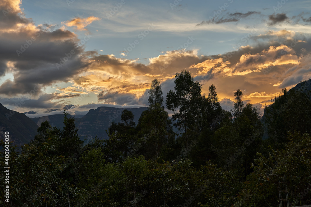 Beautiful and warm sunset with dramatic sky and illuminated clouds over the gocta waterfalls at golden hour, Peru, South amrerica