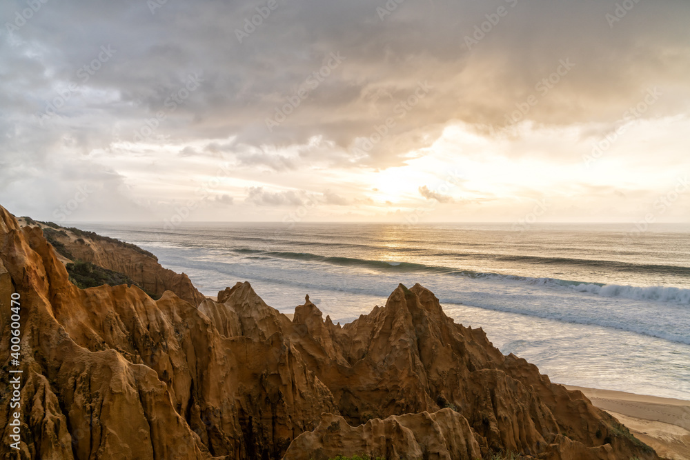 bizarre eroded sand dunes on the Atlantic Ocean with waves rolling in at sunset bizarre eroded sand dunes on the Atlantic Ocean with waves rolling in at sunset