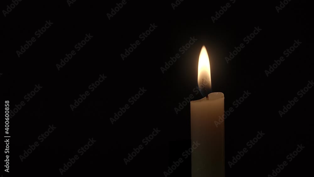 Candle. Close-up of a single candle flame burning against a black background. Candle. Close-up of a single candle flame burning against a black background.