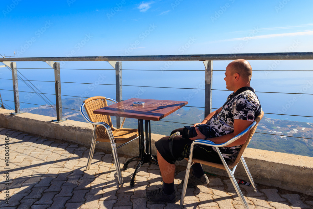 Man relax in cafe on a top of Tahtali mountain near Kemer, Antalya Province in Turkey