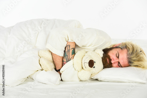 Cute teddy bear toy. Create sleep positive bedroom environment. Playful adult. Cute and romantic. Bearded hipster play toy. Man hug soft toy relaxing in bed. Lovely hipster. Make surprise concept photo