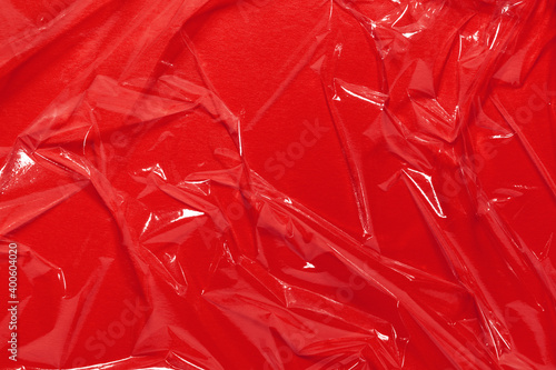 Foto Wrinkled cling film, red vinyl art background, plastic texture.