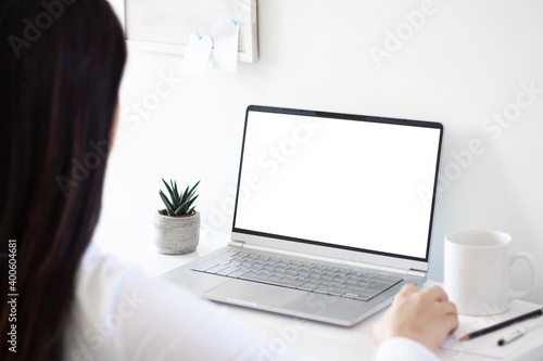 woman hand using laptop with mock up white screen. work from home concept. 