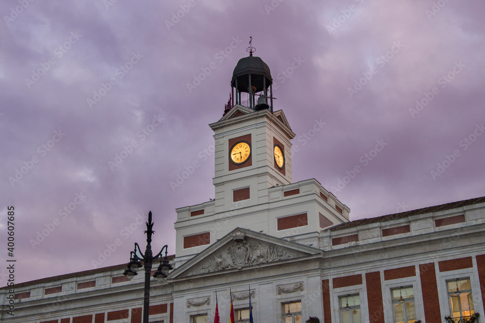 building of the Community of Madrid with the illuminated clock at dusk, in Madrid. Spain