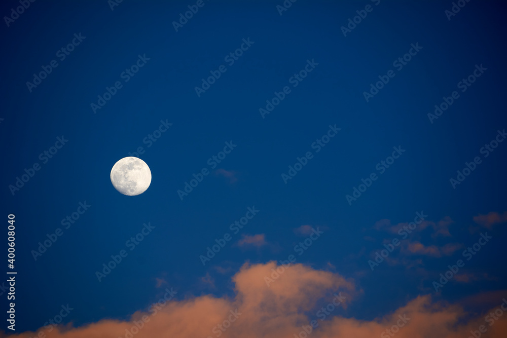 Moon in blue sky with white clouds Moon in blue sky with white clouds