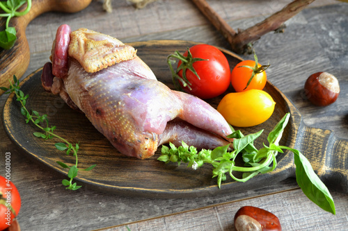 Fotografie Raw hazel grouse with vegetables on a wooden board