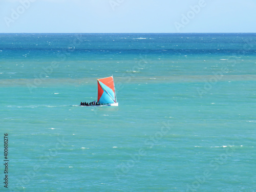 Martinican traditional sailboat sailing in the caribbean sea. Gommiers and yoles. Yole boat in turquoise waters.