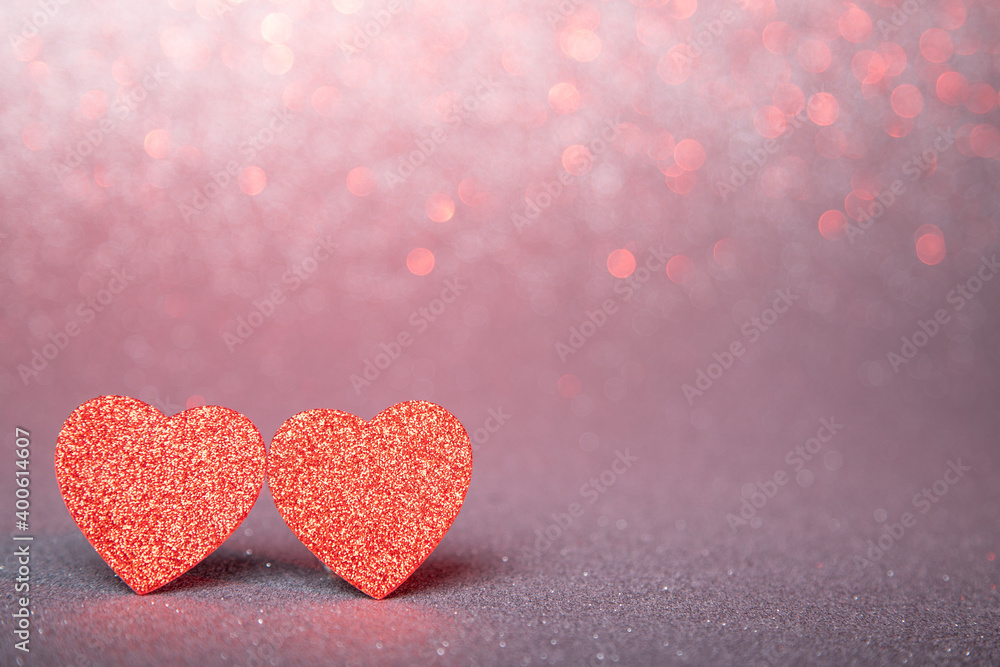 Obraz premium two red hearts in glitter on a silver and red glitter background