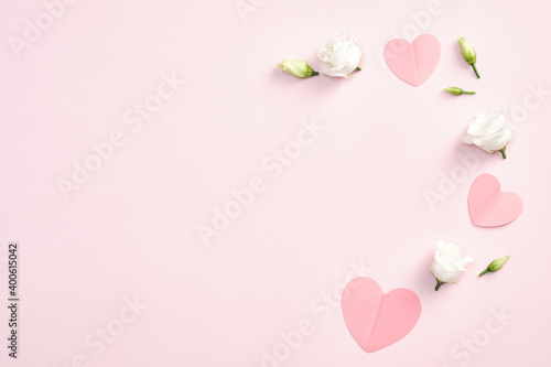 Happy Valentines Day concept. Flat lay composition with paper hearts and white rose flower on pink background. Top view with copy space.