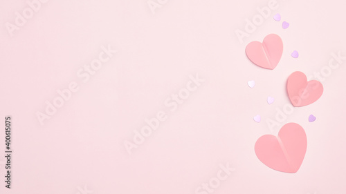 Paper hearts and confetti on pink background with copy space. Valentines Day banner design, Mothers Day greeting card template.