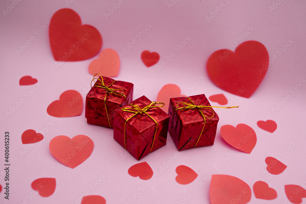 Red gift boxes and red hearts on a pink background. Valentine's day gift.