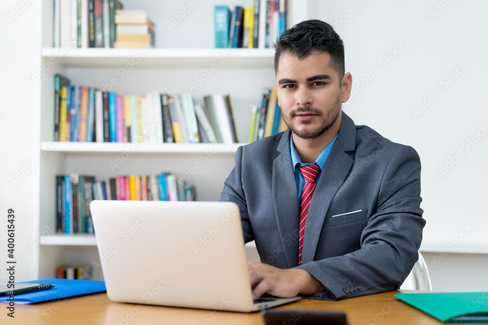 Handsome mexican businessman at computer at office Handsome mexican businessman at computer at office