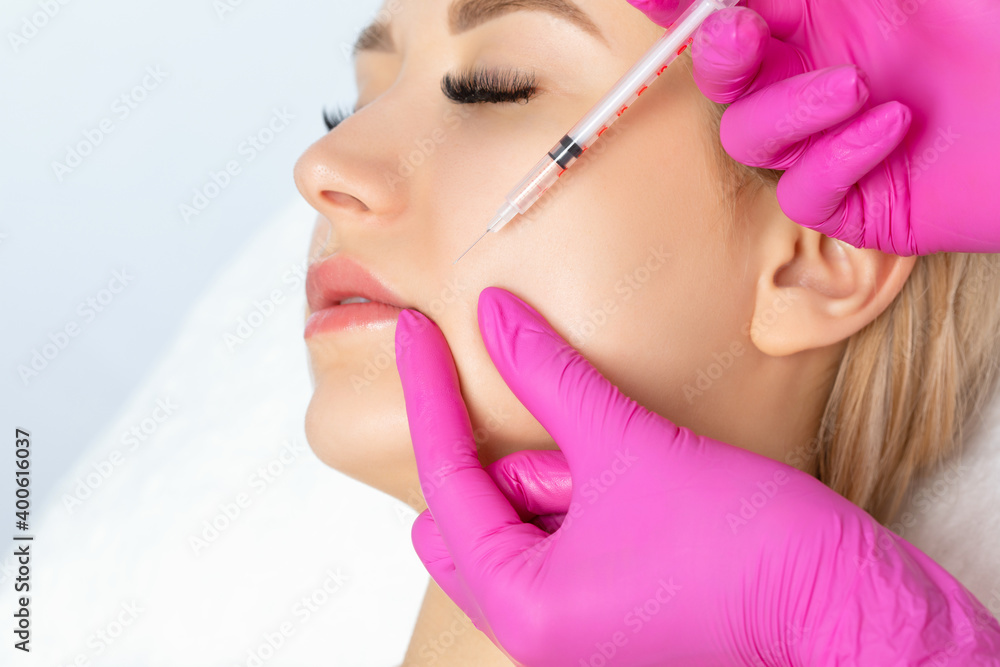 Cosmetologist makes rejuvenating anti wrinkle injections on the face of a beautiful woman. Female aesthetic cosmetology in a beauty salon. Cosmetologist makes rejuvenating anti wrinkle injections on the face of a beautiful woman. Female aesthetic cosmetology in a beauty salon.