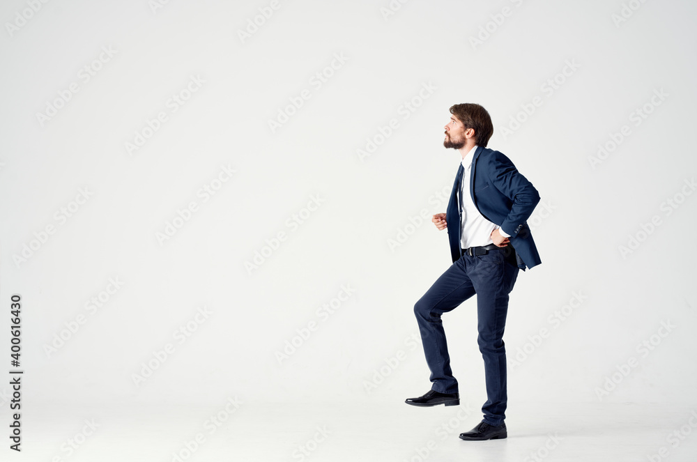 a man in a suit pulls a rope on a light background in full growth a man in a suit pulls a rope on a light background in full growth