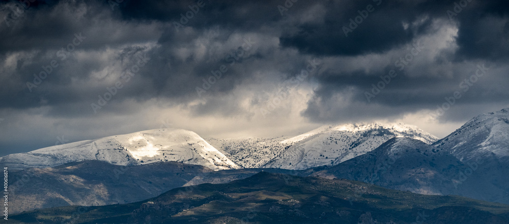 Clouds over the snow-capped mountain