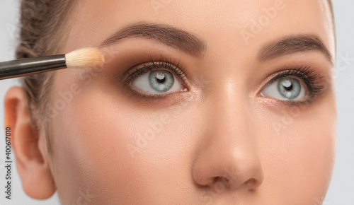 Blue eyes and eyebrows close-up. Portrait of a beautiful teenage girl with beautiful makeup, extended long eyelashes and healthy clean skin. Makeup and cosmetology concept.