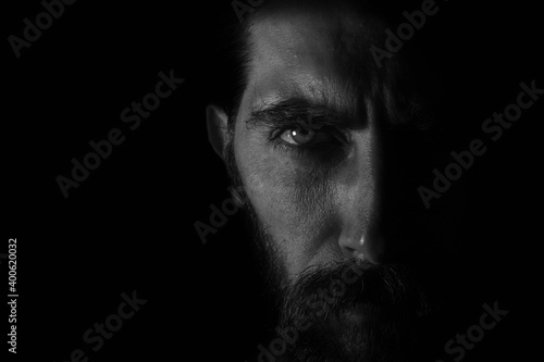 medio rostro con mirada directa en fondo negro oscuro
