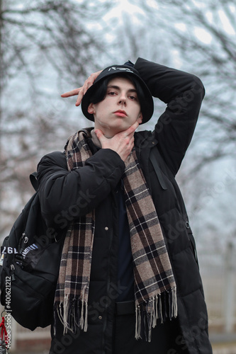 Pale guy model posing. Portrait of a young guy. Gray gloomy day, gray shades create a unique atmosphere. Dark romance.