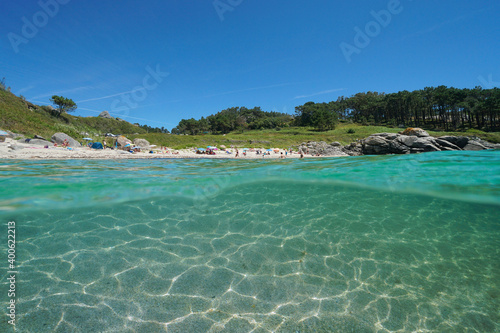 Spain Galicia coastline, beach in summer vacations and sand underwater, split view over and under water surface, Atlantic ocean, Bueu, Pontevedra province, Praia do Ancoradoiro