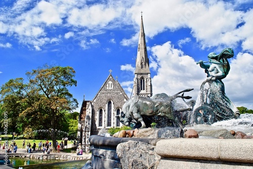 Copenhagen, Denmark: The Gefion Fountain (Danish: Gefionspringvandet) on the harbor front. It features oxen being driven by the Norse goddess Gefjon. St Alban's Church in the background.
