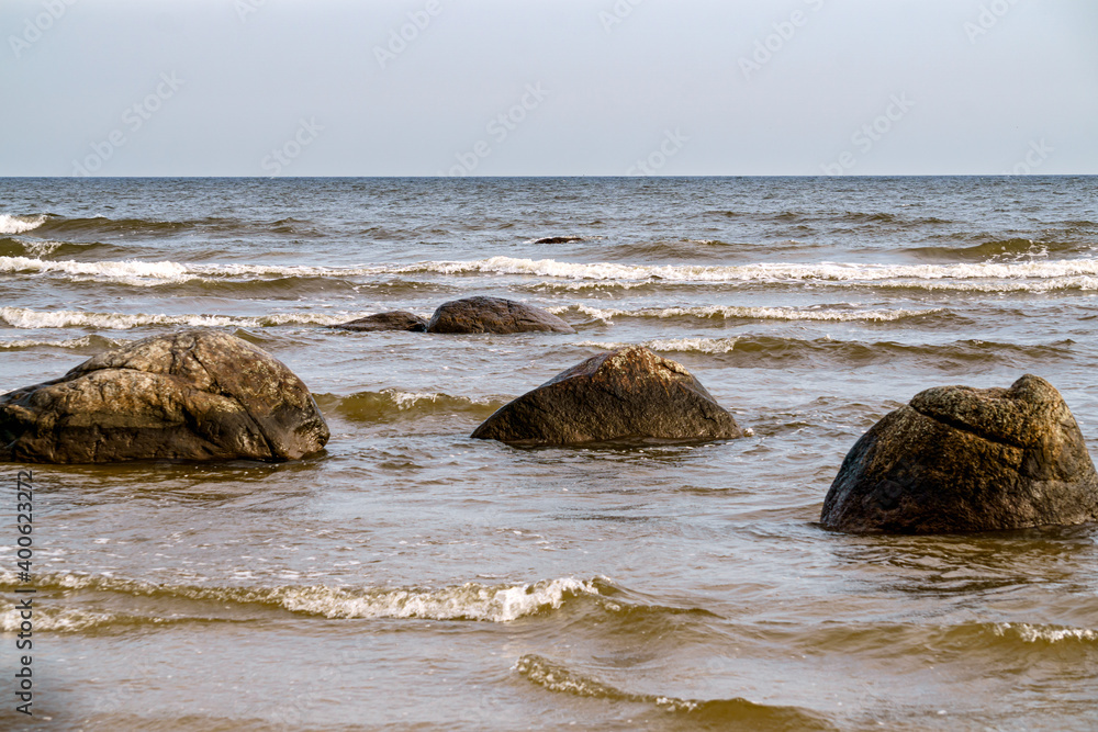 Large stone boulders on the shore of the Gulf of Riga on a summer day.