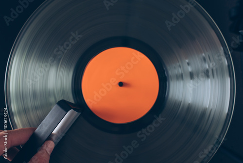 Close up of DJ hand cleaning vinyl record with carbon fiber brush photo