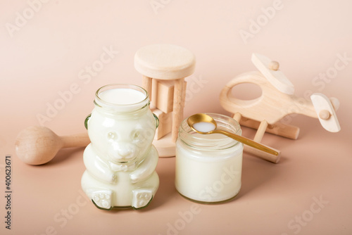Baby bottles with milk and plane on the wooden table