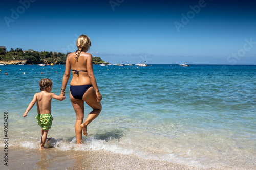 Mother and son walking into sea