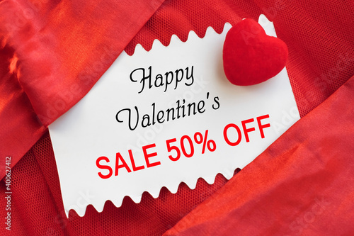 the sale with a discount is written on a white sheet, which is on a satin material with a heart. valentine's day. Banner 