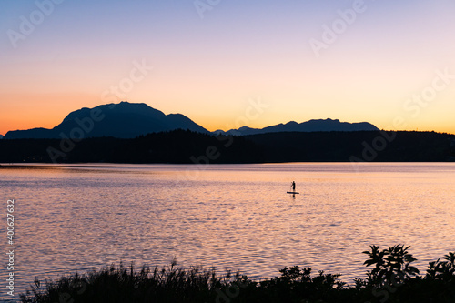Stand Up Paddle at Lake Faaker See in Carinthia  Austria. Beautiful sunset in front of Dobratsch mountain at the idyllic lake in the Alps.