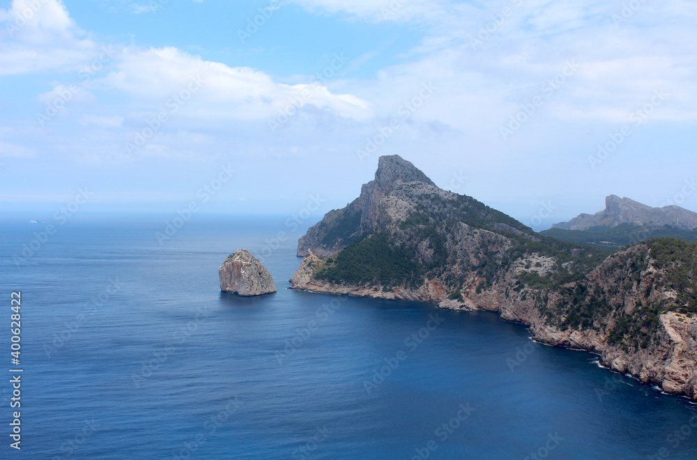 Fototapeta premium Beautiful landscape with a promontory jutting out into the sea. Soft clouds on the horizon.