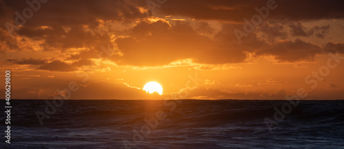Fototapeta Naklejka Na Ścianę i Meble -  sunset over the sea with big and bright sun and orange colours in the sky