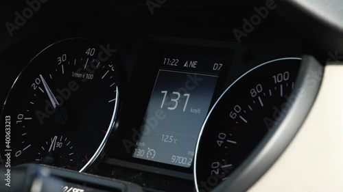 View of a modern car driving fast on highway with 130 kmh mph speed on the meter driving