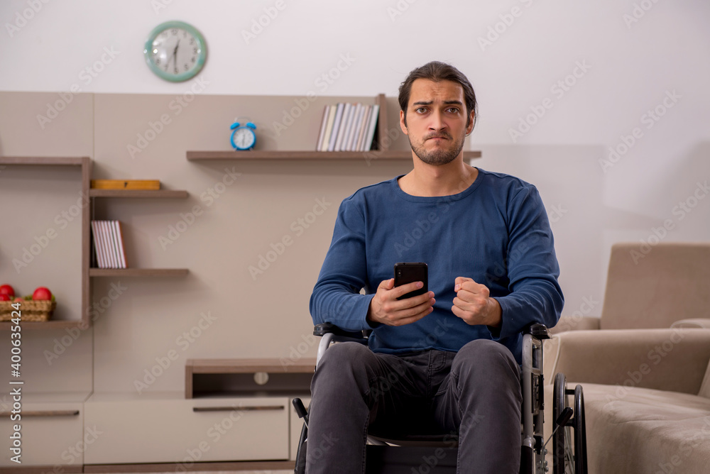 Fototapeta premium Young man in wheel-chair suffering at home