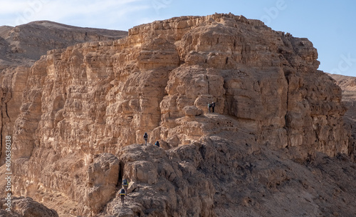Wallpaper Mural A group of hikers going along steep ridge. Hard and dangerous hiking trail. Extreme climbing and adrenaline. Amazing mountain landscape in Makhtesh Ramon, Negev desert, Israel
 Torontodigital.ca