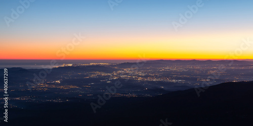 Aerial view of the city of Barcelona with city lights at sunset or sunrise. View of Barcelona, Mediterranean Sea, Catalunya-Catalonia, Spain. Panoramic view from Montseny, Turo de l'home. © Pol Solé