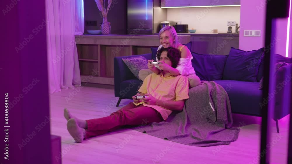 Happy couple playing video games at home during self isolation on a pandemic quarantine. Young man and woman love to spend time together. Happy couple playing video games at home during self isolation on a pandemic quarantine. Young man and woman love to spend time together.