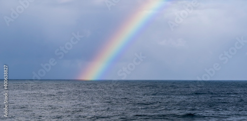 Bright and big rainbow with many colours, born from the sea to the sky