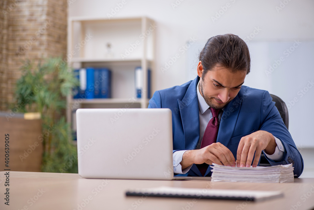 Young male employee sitting in the office in front of whiteboard Young male employee sitting in the office in front of whiteboard