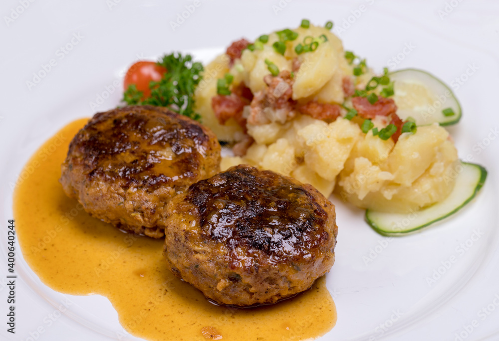 Pan-fried meatballs served with Bavarian potato cucumber salad Pan-fried meatballs served with Bavarian potato cucumber salad