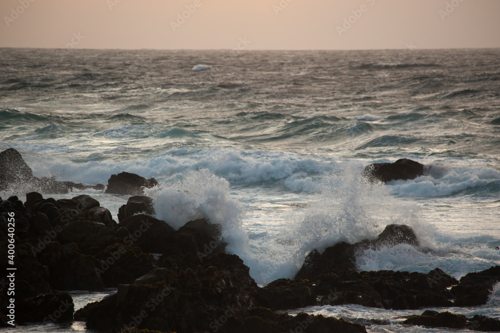 Ocean crashing onto a rocky shore at sunset Ocean crashing onto a rocky shore at sunset