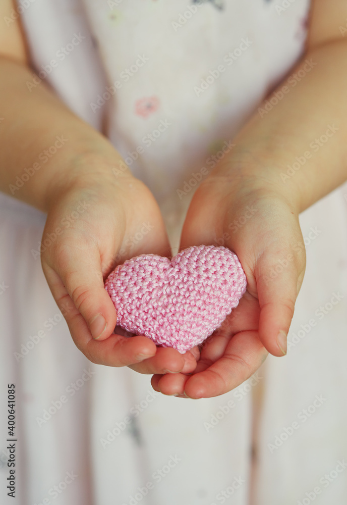 Fototapeta premium child's hands holding knitted heart