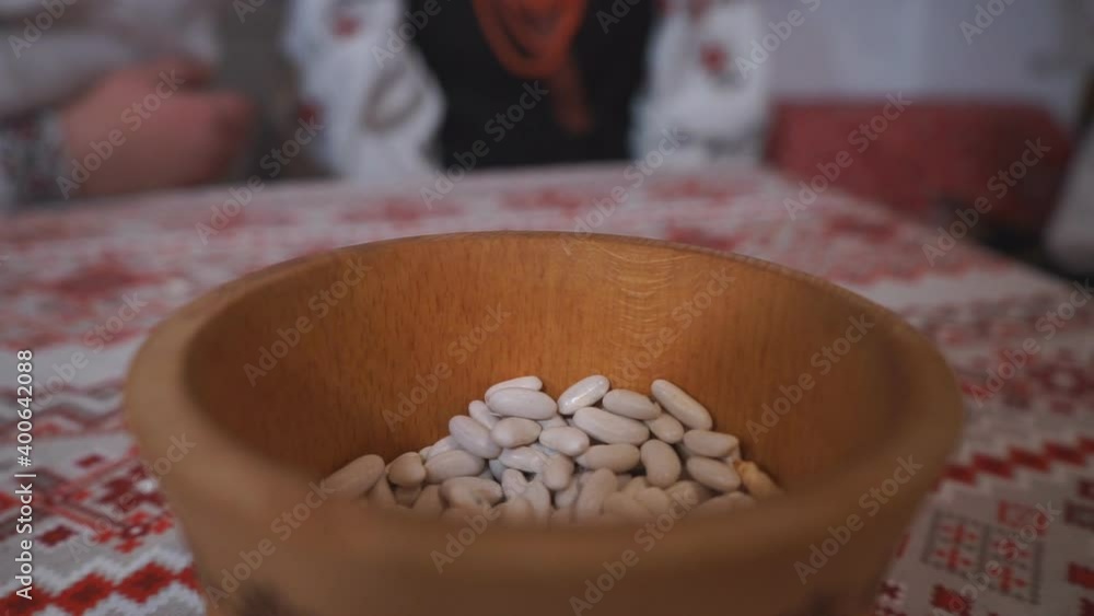 Pour white legumes into a wooden bowl located on the table Using legumes for cooking Pour white legumes into a wooden bowl located on the table Using legumes for cooking