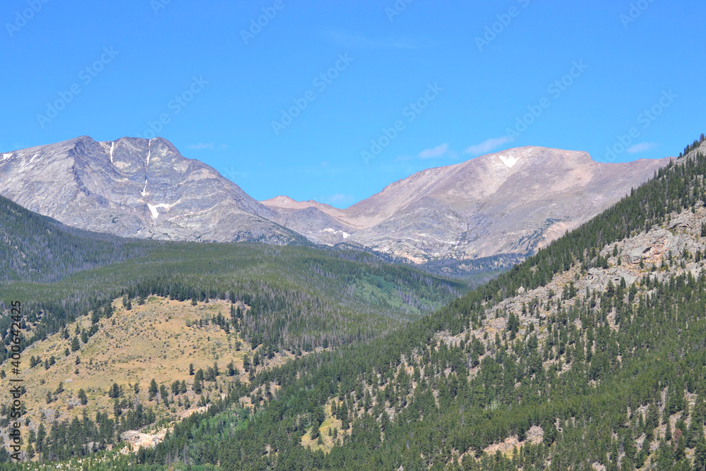 Rocky Mountain National Park in early fall. Twin peak mountains and bright blue sky near Estes Park.